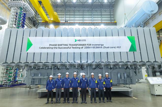 HD Hyundai Electric CEO Kim Young-ki (fifth from left) poses with company officials to celebrate the completion of the final approval test for the phase-shifting transformer at the company's plant in Ulsan. (HD Hyundai Electric)