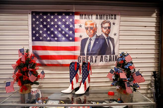 도널드 트럼프 미국 대통령과 JD 밴스 부통령의 모습이 그려진 성조기가 2025년 플로리다 제6선거구 특별선거 공화당 후보 랜디 파인의 시계 파티 장소에 놓여 있다. [로이터]