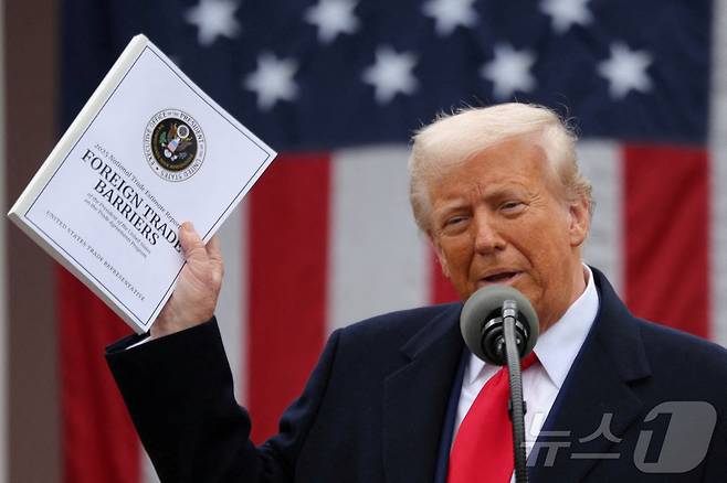도널드 트럼프 미국 대통령이 2일(현지시간) 미국 워싱턴DC 백악관 로즈가든에서 상호관세 부과와 관련한 연설을 하면서 '2025 무역 장벽 보고서' 문서를 들어 보이고 있다. ⓒ 로이터=뉴스1