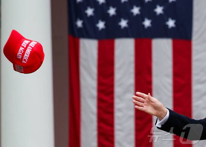 도널드 트럼프 미국 대통령이 2일(현지시간) 미국 워싱턴 DC 백악관 로즈가든에서 관세에 대한 연설을 하던 중' MAGA' 모자를 잡으려고 하고 있다. ⓒ 로이터=뉴스1