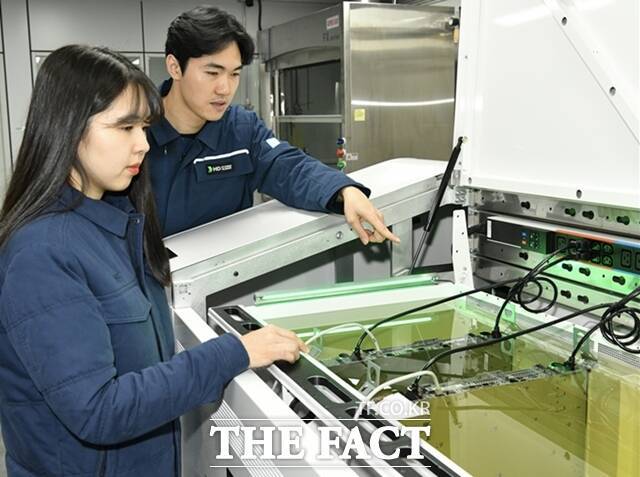 국내 정유업계가 미래 먹거리 사업으로 글로벌 기업들도 주목하고 있는 액침 냉각 시장에 뛰어들고 있다. HD현대오일뱅크 직원들이 액침냉각설비에 담긴 냉각유와 서버를 테스트하고 있다. /HD현대오일뱅크