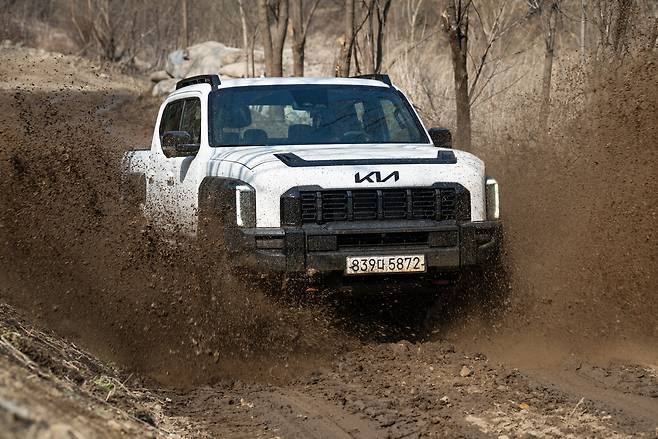Kia's new pickup truck, the Tasman, drives on a muddy road. (Kia)