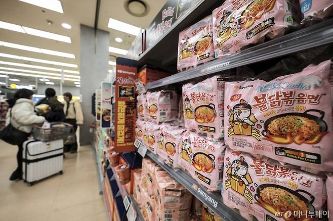 [서울=뉴시스] 정병혁 기자 = 5일 서울시내 대형마트를 찾은 여행객이 K-푸드로 인기를 끌고있는 불닭볶음면을 살펴보고 있다. 최근 10년간 라면·건강식품을 중심으로 K-푸드 수출이 크게 늘어난 것으로 나타났다.  '10년간 K-푸드 수출 동향과 시사점' 보고서에 따르면 한류 확산 등으로 K-푸드 수출액은 2015년 35억1000만 달러에서 지난해 70억2000만 달러로 증가했다. 품목군별로 보면 '라면'이 13억6000만 달러로 1위를 차지했으며, '간편식' 9억8000만 달러, '음료' 9억4000만 달러, '건강식품' 8억2000만 달러, '조미료' 6억5000만 달러 등의 순으로 수출이 많았다. 2025.03.05. jhope@newsis.com /사진=정병혁