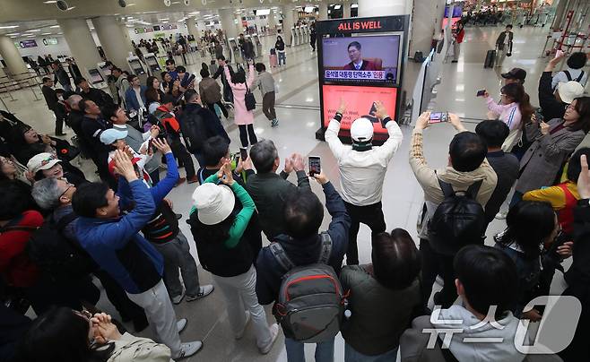 4일 오전 제주국제공항 국내선 출발장에서 관광객과 도민들이 윤석열 대통령의 탄핵심판 선고 TV 생중계를 지켜보다 파면이 결정되자 환호하고 있다. 이날 헌법재판소는 재판관 전원 일치 의견으로 윤 대통령 파면을 결정했다. 2025.4.4/뉴스1 ⓒ News1 오현지 기자