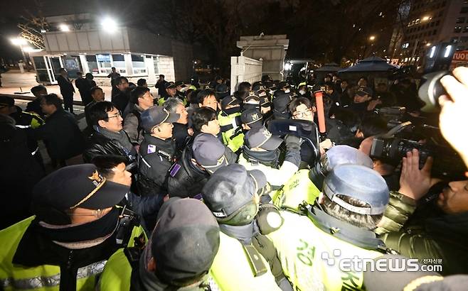 윤석열 대통령이 3일 밤 비상계엄령을 선포한 가운데 폐쇄가 결정된 국회 정문에서 경찰과 국회 관계자들이 대치하고 있다.   김민수기자 mskim@etnews.com