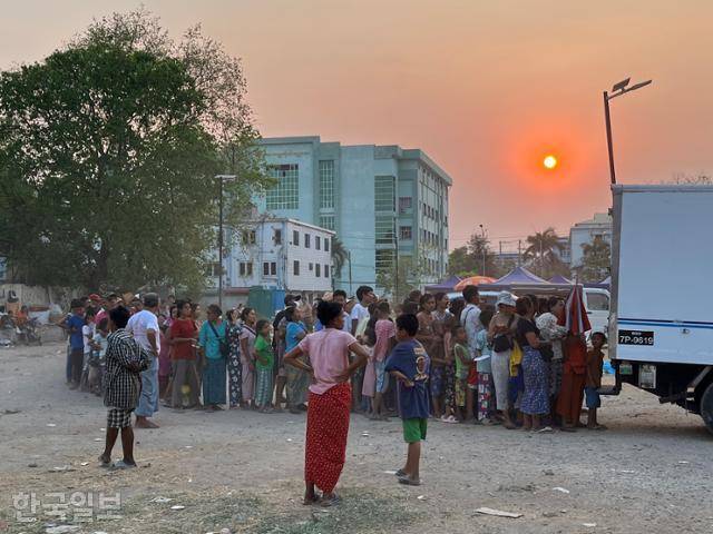 만달레이 찬 아예 타르잔 지역 공터에 마련된 난민촌에 머무는 만달레이 시민들이 구호 물자를 얻으려 길게 줄을 서 있다. 만달레이(미얀마)=허경주 특파원
