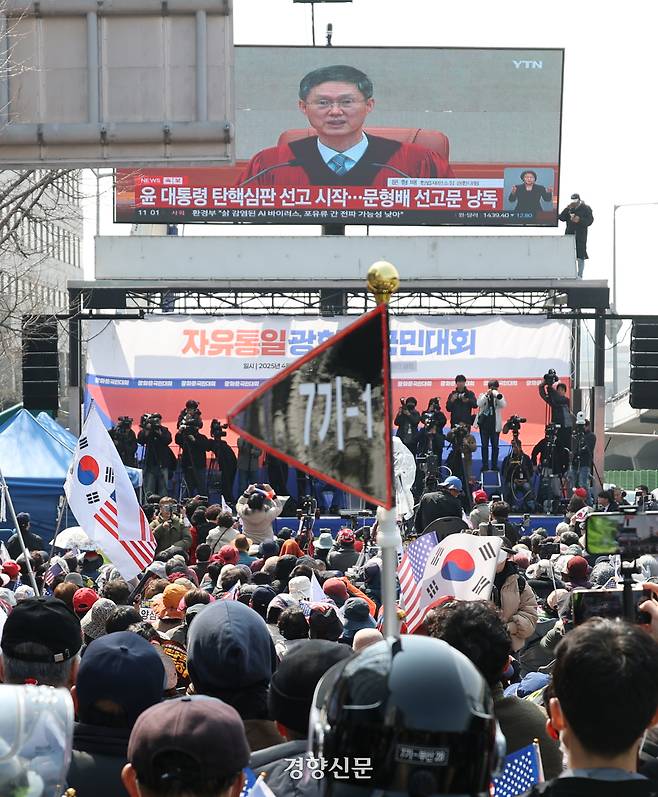 윤석열 대통령 탄핵 선고일인 4일 오전 서울 한남동 대통령 관저 입구에서 윤 대통령 지지자들이 헌재 선고 생중계를 보고 있다. 성동훈 기자
