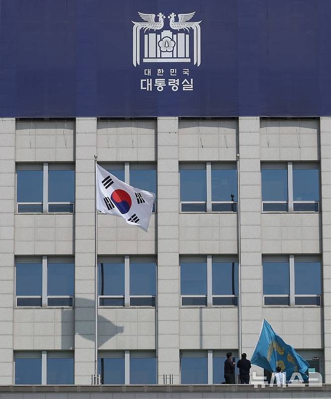 [서울=뉴시스] 조수정 기자 = 헌법재판소가 윤석열 대통령의 탄핵사건에 대해 인용을 선고한 4일 서울 용산 대통령실 청사에서 관계자들이 봉황기를 하기하고 있다. 2025.04.04. chocrystal@newsis.com