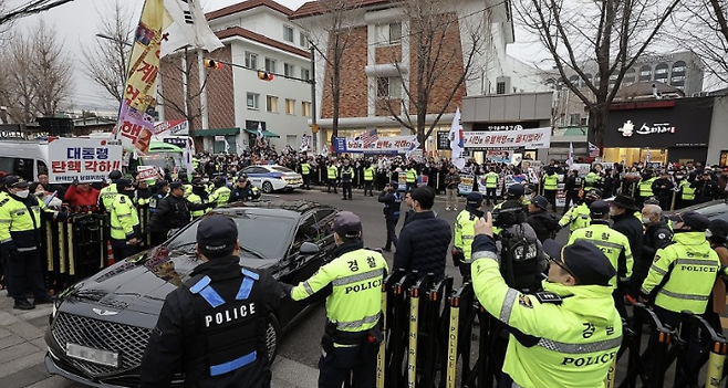12일 윤석열 대통령 지지자들이 탄핵 각하 집회를 하고 있는 서울 종로구 헌법재판소 앞에서 경찰 등 경호 인력 차량 출입로를 통제하고 있다. 연합뉴스