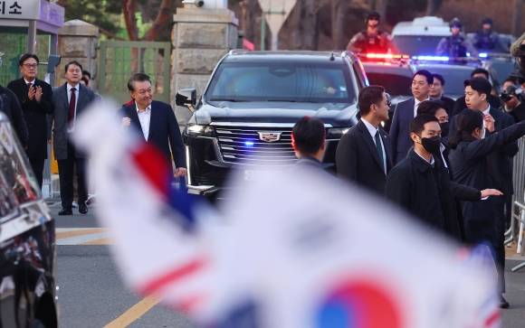 석방된 윤석열 대통령이 8일 경기도 의왕시 서울구치소 앞에서 경호차량에서 내려 지지자들에게 인사하며 주먹을 불끈 쥐어보이고 있다. 의왕 연합뉴스