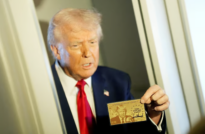 트럼프 대통령이 전용기 에어포스원 기내에서 70억원대 영주권 카드인 '골드 카드'를 보여주고 있다. 사진=로이터 연합뉴스