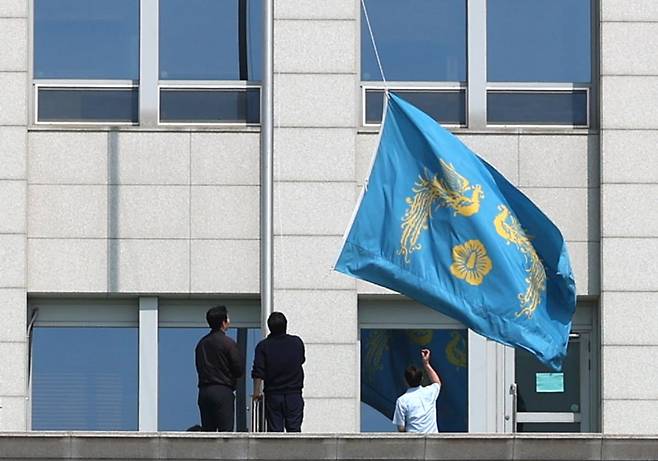 지난 4일 서울 용산구 대통령실에 걸려있던 봉황기(왼쪽)가 헌법재판소의 윤석열 대통령 탄핵 인용 이후 대통령실 관계자들에 의해 내려지고 있다. 사진=대통령실사진기자단