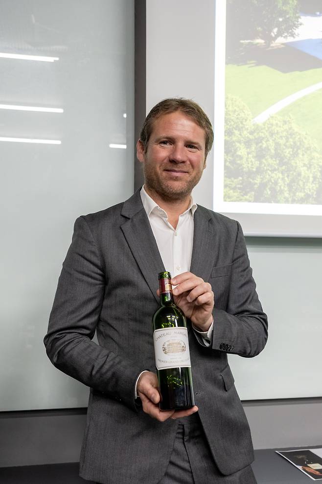 지난 3월 한국을 찾은 오를리앙 발랑스 샤또 마고 부사장이 샤또 마고 2009 빈티지를 들고 포즈를 취하고 있다. [사진=전형민 기자]