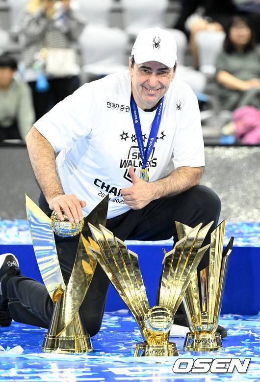 [OSEN=인천, 이대선 기자] 현대캐피탈 스카이워커스가 구단 통산 5번째 챔피언결정전 우승을 달성했다.&nbsp;현대캐피탈은 5일 인천 계양체육관에서 열린 ‘도드람 2024-2025 V-리그’ 챔피언결정전 3차전 대한항공 점보스와의 경기에서 세트스코어 3-1(25-20, 18-25, 25-19, 25-23)로 승리하며 시리즈 전적 3승으로 챔피언결정전 우승을 차지했다. 2018-2019시즌 이후 6년 만에 우승이다. 정규리그 1위를 포함한 통합우승은 2005-2006시즌 이후 19년 만이며 트레블을 달성한 것은 이번이 처음이다.현대캐피탈 필립 블랑 감독이 트로피를 배경으로 기념촬영을 하고 있다. 2025.04.05 /sunday@osen.co.kr