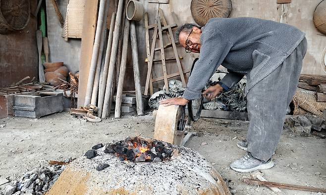 고석산 석장이 작업 도구를 전통방식으로 수리하기 위해 풀무를 이용해 가마에 불을 피우고 있다.