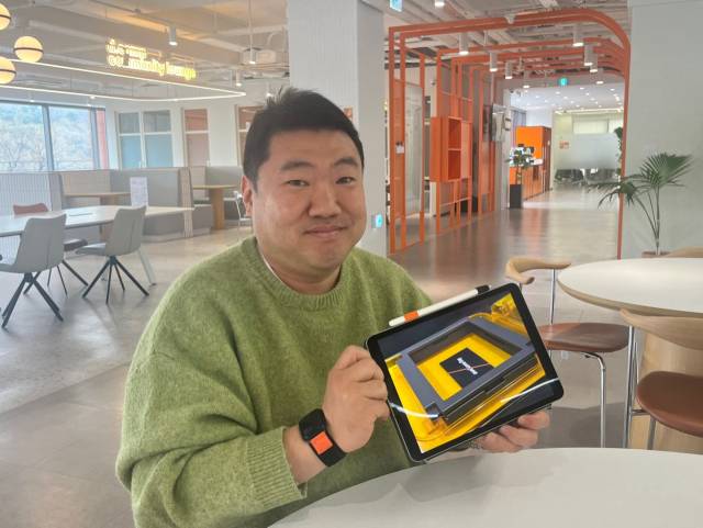 지난 2일 서울 강남구 디캠프에서 진행된 서울경제신문과의 인터뷰에서 김세훈 어썸레이 대표가 풀 사이즈로 구현한 CNT 소재의 사진을 보여주고 있다. /정혜진기자