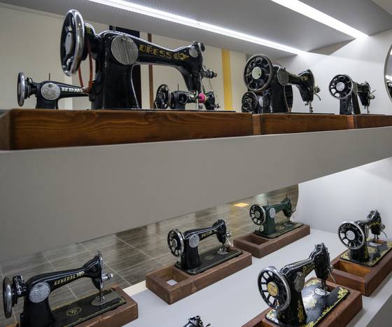 꽃무늬 재봉틀부터 휴대용 재봉틀까지 19세기 말부터 20세기까지 생산된 재봉틀 90점이 전시된 아트월.