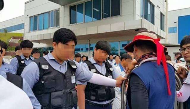 ▲ 아사히글라스가 고용한 용역들이 비정규직 노동자들의 회사 진입을 막고 있다. ⓒ아사히글라스비정규직지회