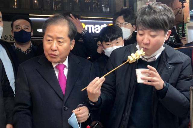 2022년 2월 12일 당시 국민의힘 홍준표(왼쪽) 의원과 이준석 당 대표가 대구 동성로의 한 어묵가게에서 함께 어묵을 먹고 있다. 대구 = 뉴스1