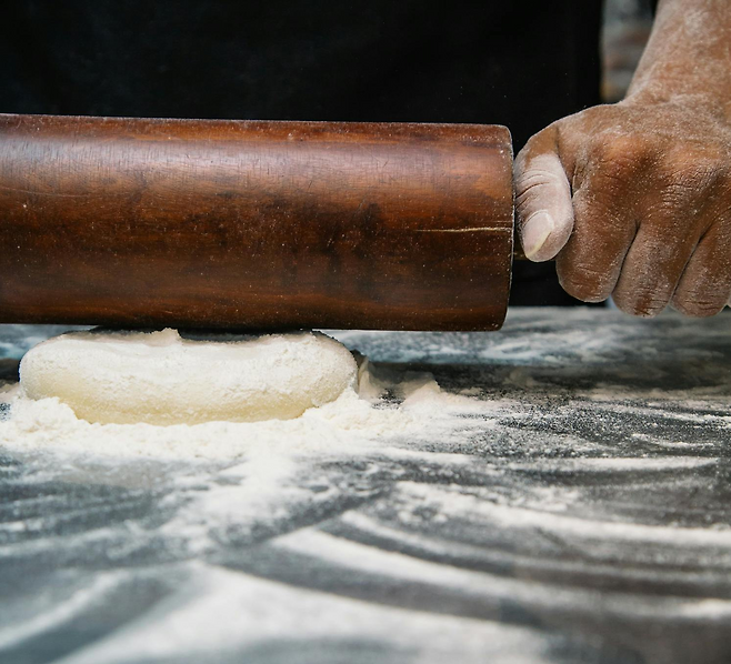 밀대로 밀가루 반죽을 밀고 있는 모습