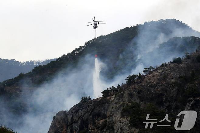 경북 청송군 주왕산면 상의리 주왕산 국립공원 산불 현장에 투입된 헬기가 산불 진화를 위해 물을 뿌리고 있다. 밤사이 산불이 조계종 천년고찰 대전사 인근까지 근접하는 등 위기가 닥쳤다. 2025.3.27/뉴스1 ⓒ News1 공정식 기자