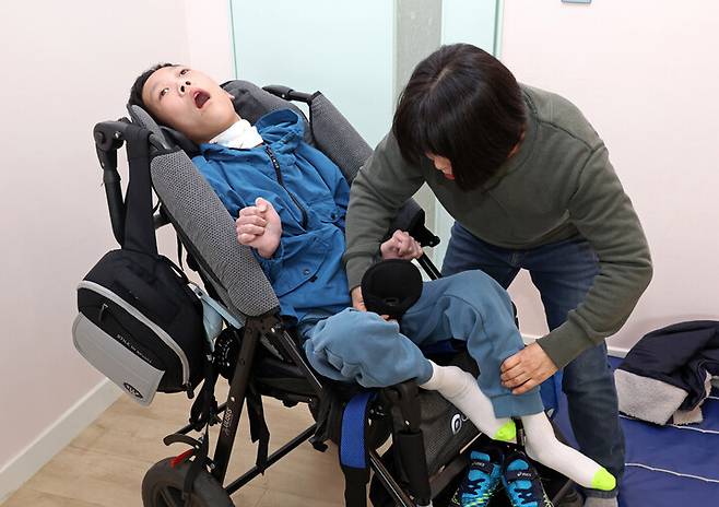 희귀질환 ‘위커 울프 증후군’을 가진 천석현군의 엄마 조묘숙씨가 석현군을 휠체어에 앉히고 있다. 김영원 기자 forever@hani.co.kr