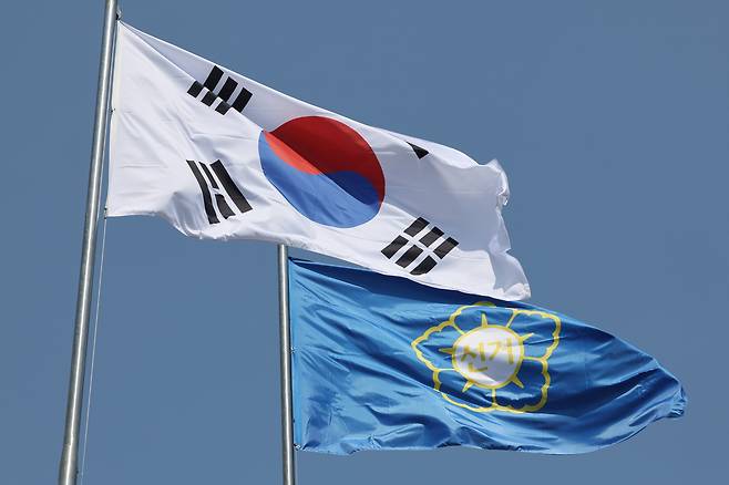 South Korea's national flag (left) and a flag representing election authorities are seen in a photo taken near the National Election Commission headquarters in Gwacheon, Gyeonggi Province, Sunday. (Yonhap)