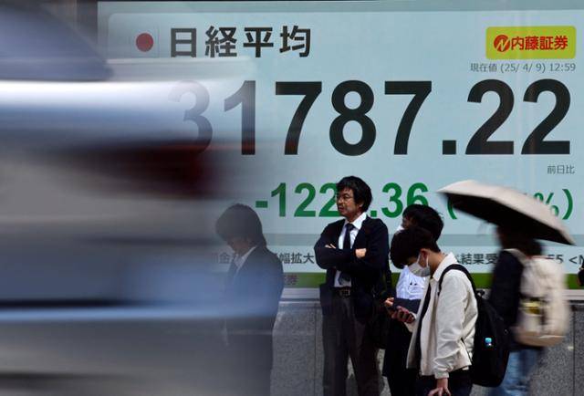 일본 도쿄 시민들이 한 증권사 사옥 외부에 설치된 대형 스크린 앞에 서 있다. 스크린에는 닛케이225 평균주가가 나오고 있다. 도쿄=로이터 연합뉴스