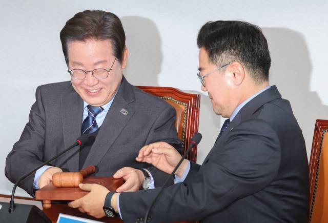 이재명 더불어민주당 대표가 9일 서울 여의도 국회에서 열린 최고위원회의에서 사퇴 의사를 밝힌 뒤 권한대행을 맡을 박찬대 원내대표에게 의사봉을 넘기고 있다. 연합뉴스