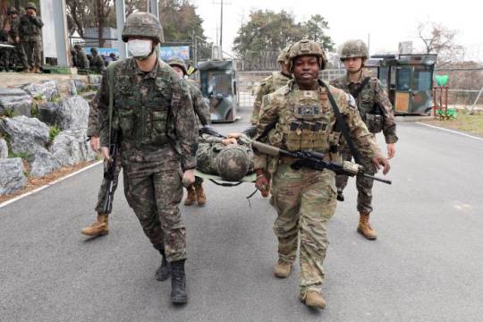미8군 탱고경비중대원들과  한국군 예비군들이 전투부상자처치 교육 중 들것으로 부상자를 옮기고 있다. 국방일보 제공