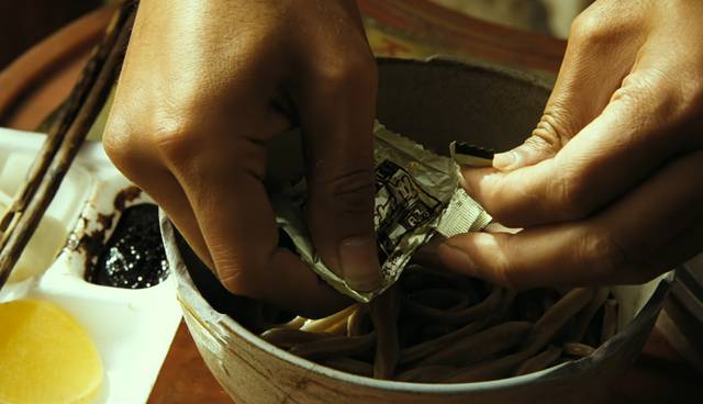 소중하게 간직해온 짜장 분말수프를 면 위에 뿌리는 장면. 사진=영화 ‘김씨 표류기’ 장면 캡처