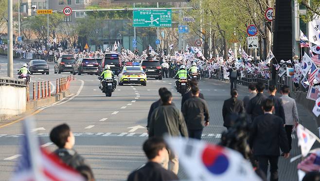 11일 오후 서울 용산구 대통령 관저를 떠나는 윤석열 전 대통령 부부를 태운 차량 행렬이 지지자들이 태극기를 흔드는 한남대로를 지나고 있다./김지호 기자