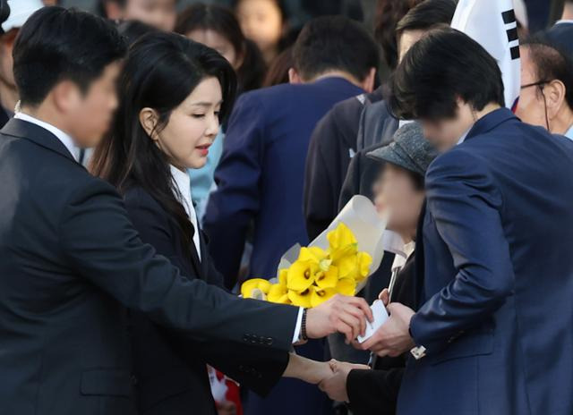 김건희 여사가 11일 서울 서초구 아크로비스타 자택으로 향하며 지지자로부터 꽃다발을 선물받고 있다. 연합뉴스