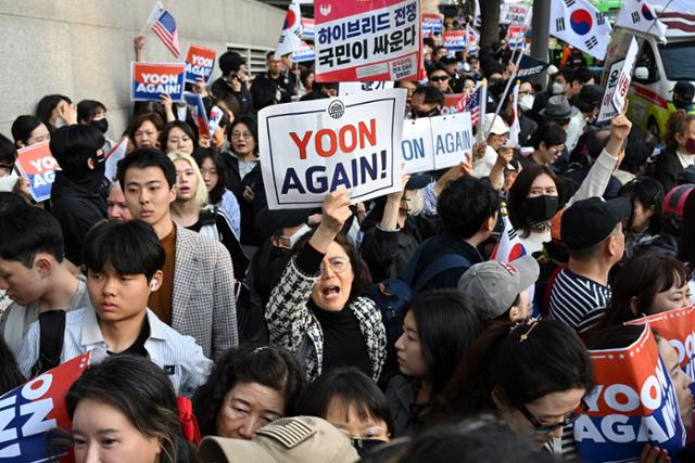 윤석열 전 대통령이 관저를 떠나 자택으로 이주한 11일 윤 전 대통령 지지자들이 서울 서초구 아크로비스타에서 복귀하는 윤 전 대통령을 향해 환호하고 있다. 박시몬 기자