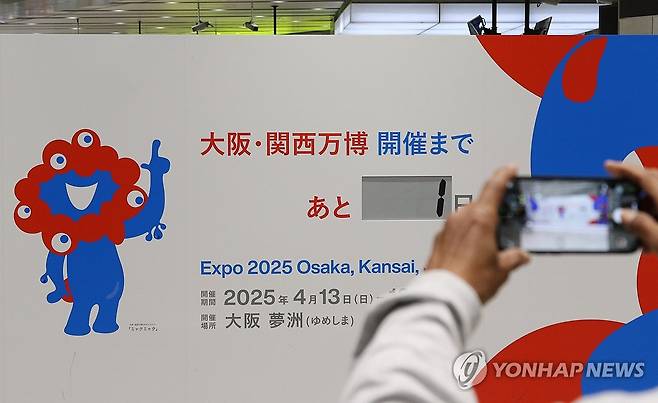 개막 하루 앞으로 다가온 오사카 엑스포 (오사카=연합뉴스) 박상현 특파원 = 일본 오사카·간사이 만국박람회(오사카 엑스포) 개막을 하루 앞둔 12일 신오사카역에서 사람들이 엑스포 안내판을 배경으로 사진을 찍고 있다.