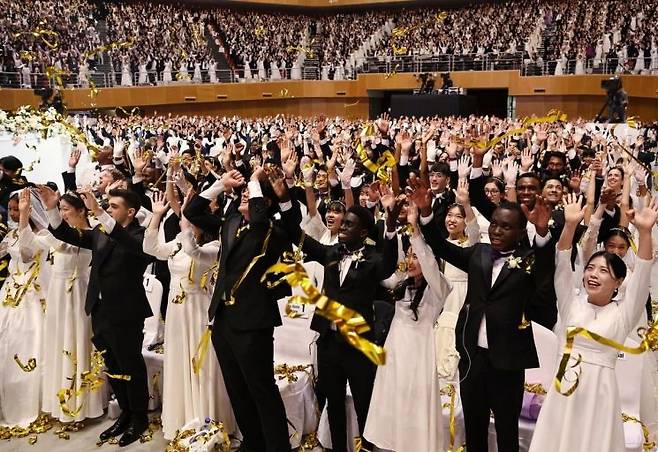 세계평화통일가정연합(옛 통일교)이 12일 경기 가평군 소재 청심평화월드센터에서 개최한 국제 합동결혼식에서 신랑·신부들이 밝은 표정으로 두손을 들고 있다.세계평화통일가정연합 제공