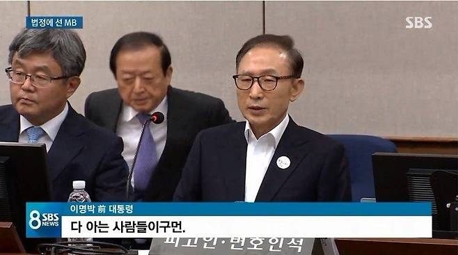 2018년 5월23일 이명박 전 대통령이 자신의 뇌물수수 등 혐의 사건 첫 공판에 출석해 맞은 편 검사석을 바라보며 발언하고 있다. SBS 뉴스 캡처