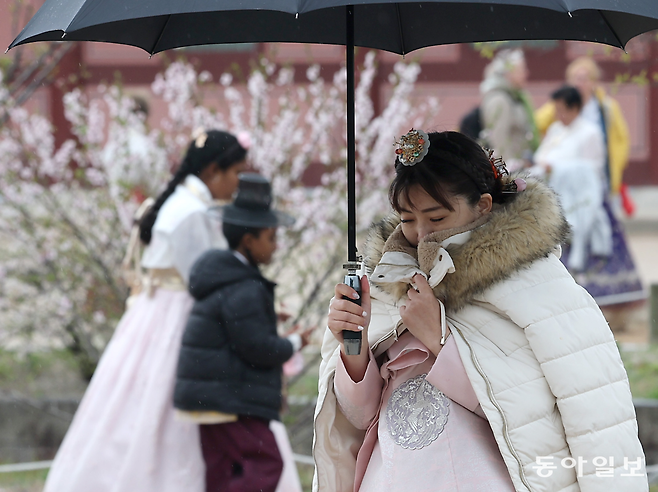 전국에 돌풍과 눈, 비가 내리며 쌀쌀한 날씨를 보인 14일 오전 서울 종로구 경복궁에서 한 외국인 관광객이 외투로 얼굴을 가린 채 걸어가고 있다. 송은석 기자 silverstone@donga.com