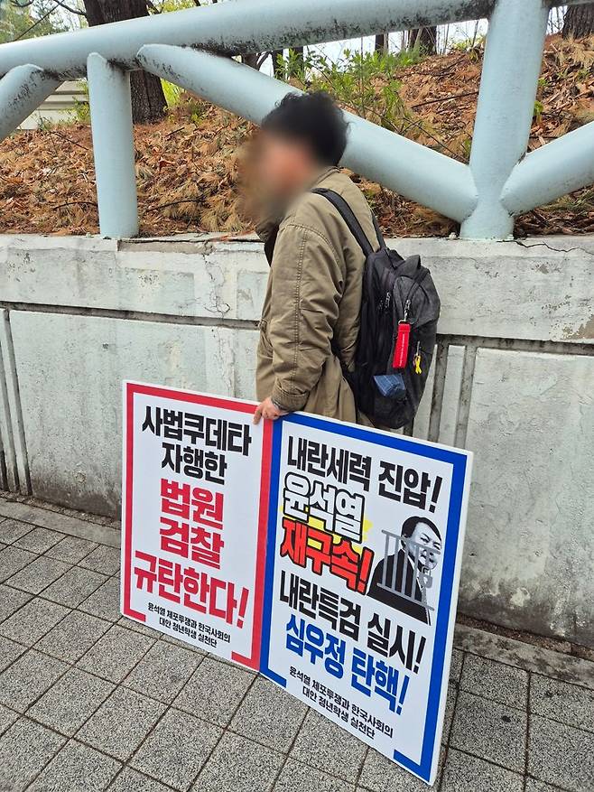 14일 서울 서초구 소재 서울중앙지방법원 동문 담벼락에서 '윤석열 재구속' 1인 시위를 진행하고 있는 30대 A씨. 사진=김예지 기자