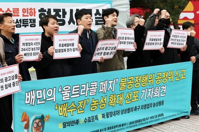(서울=뉴스1) 오대일 기자 = 온라인플랫폼법제정촉구공동행동 소속 자영업자와 시민사회단체 회원들이 12일 서울 송파구 우아한형제들 본사 앞에서 열린 '배달의민족 울트라콜 폐지 불공정 행위 신고 및 상생협의 촉구 농성 총력전 선포 기자회견'에서 배달앱 수수료 인하와 상생협의를 촉구하는 구호를 외치고 있다. 2025.3.12/뉴스1  Copyright (C) 뉴스1. All rights reserved. 무단 전재 및 재배포,  AI학습 이용 금지. /사진=(서울=뉴스1) 오대일 기자
