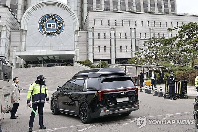 지하주차장 향하는 윤 전 대통령 차량 (서울=연합뉴스) 내란 우두머리 혐의로 기소된 윤석열 전 대통령의 첫 형사재판이 열리는 14일 윤 전 대통령이 탑승한 차량이 서울 서초구 서울중앙지방법원 지하주차장으로 들어가고 있다. 2025.4.14 [사진공동취재단] photo@yna.co.kr