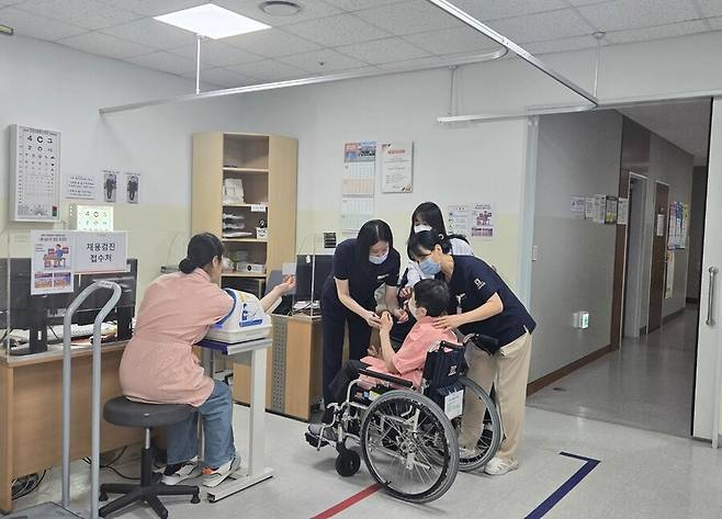 서울의료원 간호사들이 건강검진 과정에서 시력을 재고 있는 여성 장애인의 안전을 위해 옆을 지키며 도움을 주고 있다. 장애인 검진에 시간이 걸리긴 하지만, 비장애인 수검자들도 차분히 순서를 기다리는 분위기다. 김소연 기자 dandy@hani.co.kr