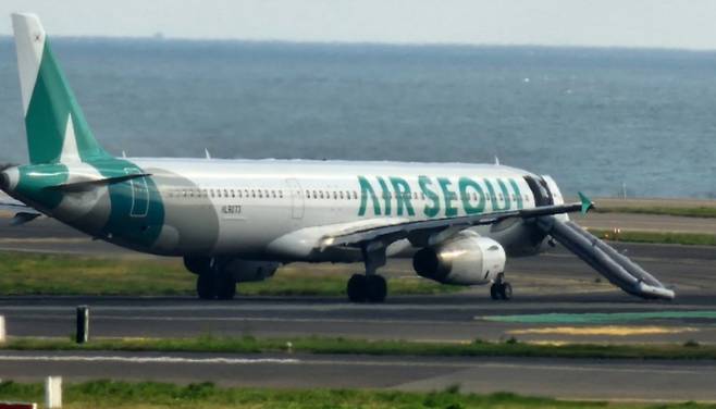 제주공항 활주로에 멈춰선 에어서울 여객기. 개방된 비상문 아래로 탈출용 슬라이드가 전개돼 있다. 항공기는 P유도로 인근에서 비상문이 열리며 슬라이드가 작동했고, 이후 기동불능 상태로 주기장에 견인됐다. (시청자 제공)