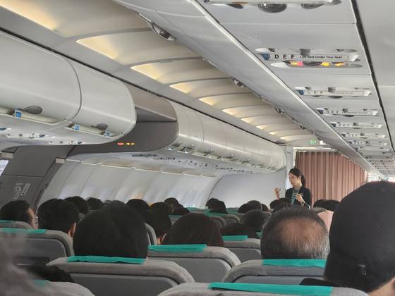 15일 오전 9시쯤 제주공항에서 멈춰선 에어서울 해당항공기 기내에서 승무원이 승객들에게 상황을 설명하고 있다. 독자제공