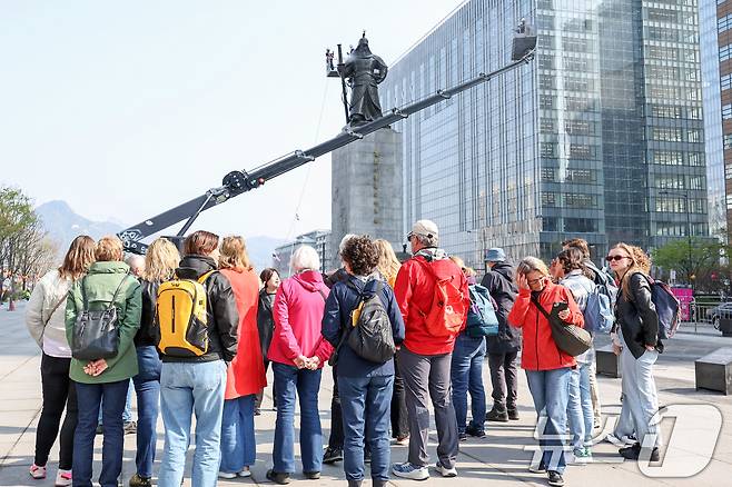 16일 오전 서울 종로구 광화문광장에서 외국인 관광객들이 이순신 장군 동상을 세척하는 모습을 바라보고 있다. 2025.4.16/뉴스1 ⓒ News1 민경석 기자
