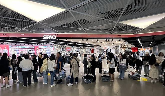 이랜드월드가 운영하는 SPA(제조·유통 일괄) 브랜드 ‘스파오’ AK플라자 홍대점 매장에 제품을 결제하려는 손님들이 긴 줄을 서 있다. 2009년 이랜드가 출시한 스파오는 가성비를 앞세워 최근 3년간 연 20%대의 매출 성장률을 보이고 있다./이랜드월드