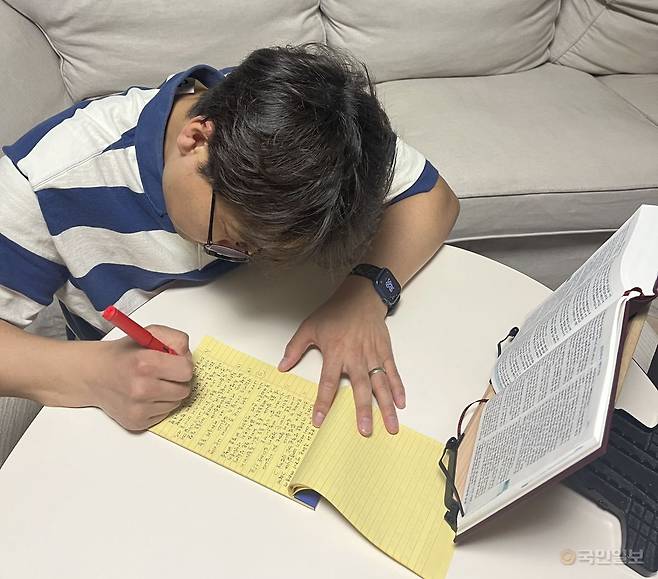 손동준 국민일보 기자가 14일 경기도 자택에서 퇴근 후 성경 필사를 하고 있다. 손 기자 아내 제공