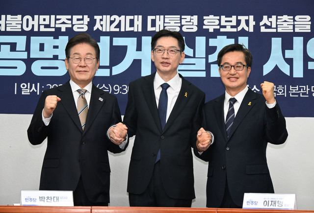 더불어민주당 대선 후보 경선 주자인 이재명 전 대표, 김경수 전 경남지사, 김동연 경기지사(왼쪽부터)가 16일 서울 여의도 국회에서 열린 공명선거 실천 서약식에서 서약문에 서명한 뒤 손을 잡고 기념촬영을 하고 있다. 이병주 기자