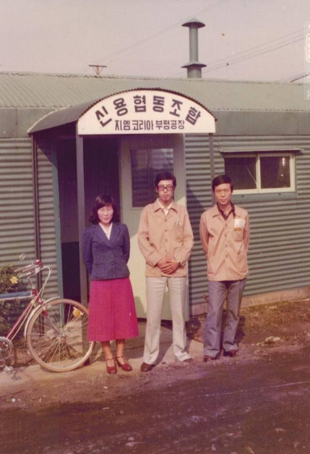 1974년 이창호(가운데) 더불어사는사람들 대표가 지엠코리아 신용협동조합 앞에서 사진 촬영을 하고있다. 사진 제공=더불어사는사람들