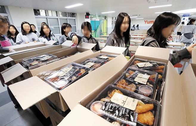 미역 없는 미역국… 대전서 급식 불만 폭발 “얘들아 오늘도 단체 도시락이야” - 16일 급식 중단 사태를 겪고 있는 대전 중구 글꽃중에서 학생들이 줄지어 학교 측에서 임시 제공한 도시락을 받고 있다. 이 학교는 급식 조리원들이 미역 자르기와 계란 까기 등 까다로운 식재료 손질 업무를 거부해 ‘미역 없는 미역국’이 제공되는 등 파행을 겪다가 조리원들이 단체 병가를 내 급식이 중단됐다. /신현종 기자